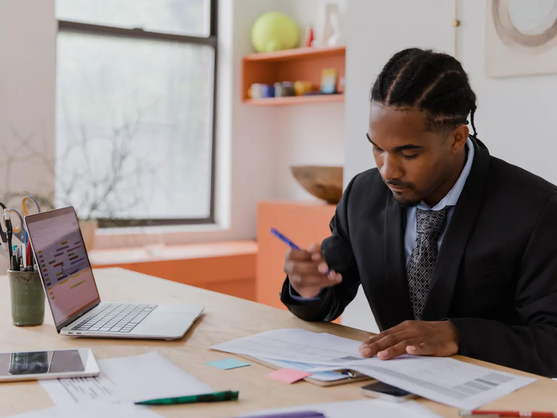 A business owner reviewing corporate tax documents at his desk