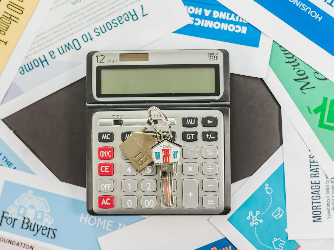A calculator and mortgage rate documents on a desk