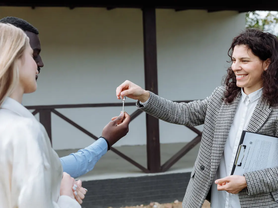 A broker handing over house keys after a mortgage renewal